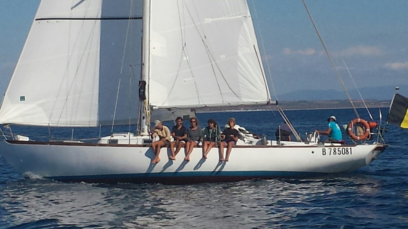 Alcuni partecipanti al corso di vela siedono sul bordo della barca